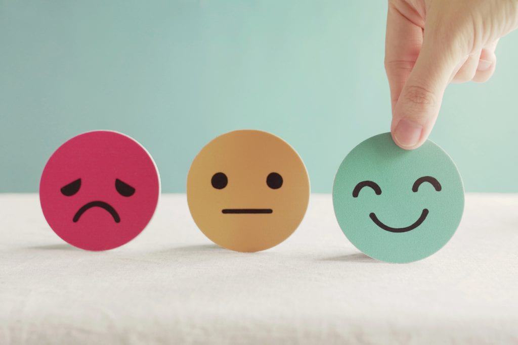 Icons of sad, neutral and happy faces mental illness stigma