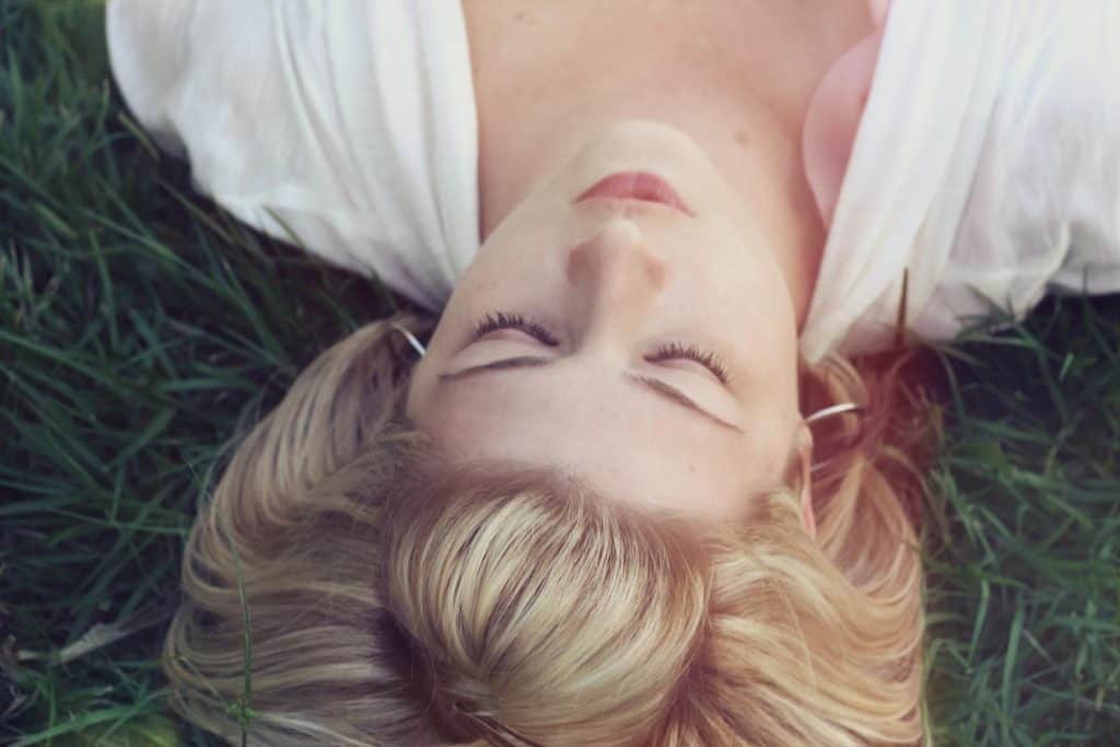 Woman lying on the grass progressive muscle relaxation therapy