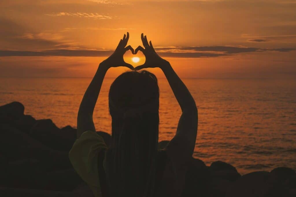 heart shaped hands at sunset - addicted to romance