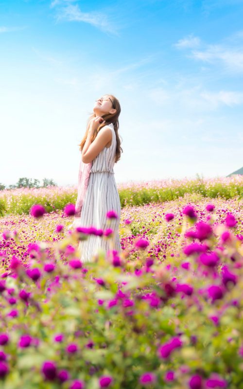 Woman walking through a field of flowers